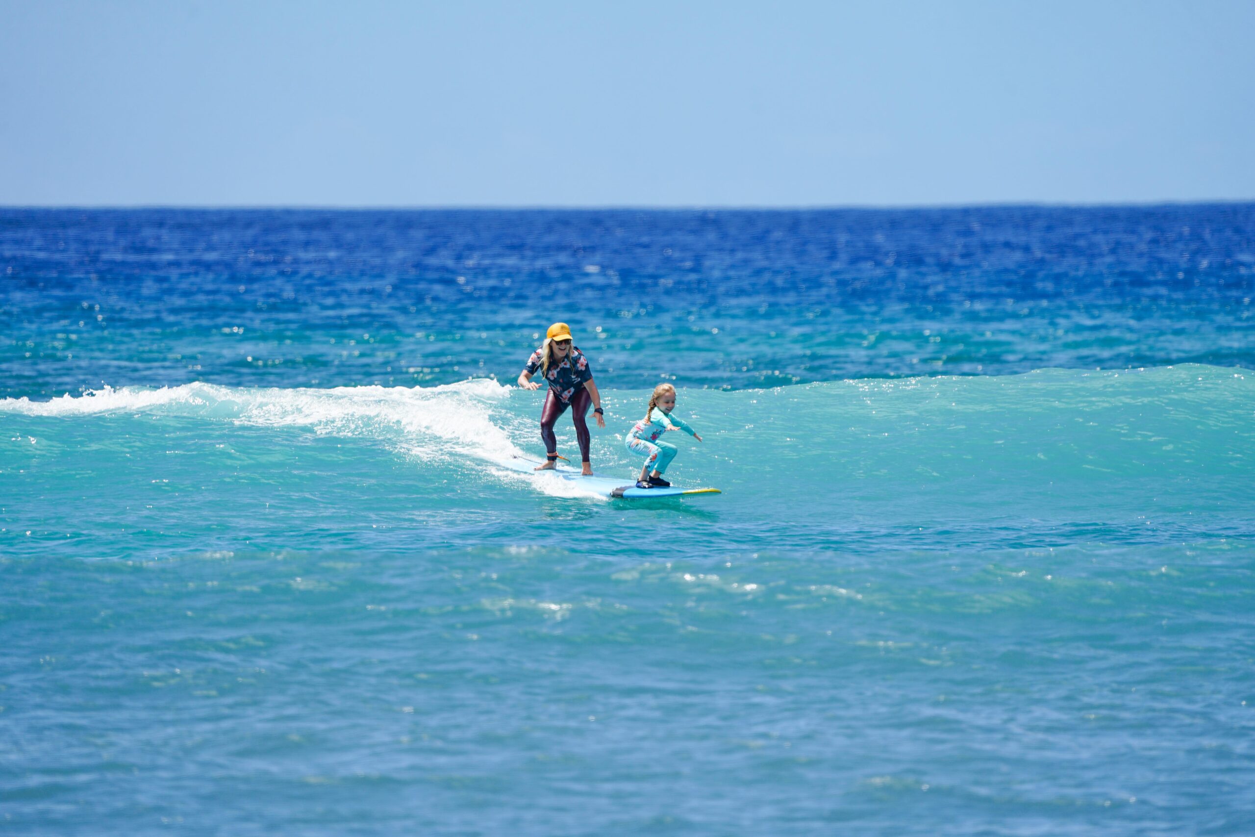Maui Surfer Girls founder Dustin Tester surfs tandem with a youngsetr during a lesson recently at Ukumehame Beach Park. @rachaelzimmermanphotography photo