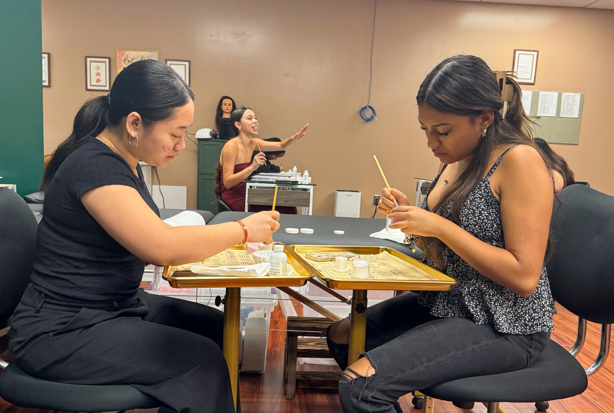 Jhanine Roflo Rumbaoa (left) and Seyna Palacios practice nail technology on Thursday in their Beauty Operator Program at UH Maui College. HJI / ROB COLLIAS photo