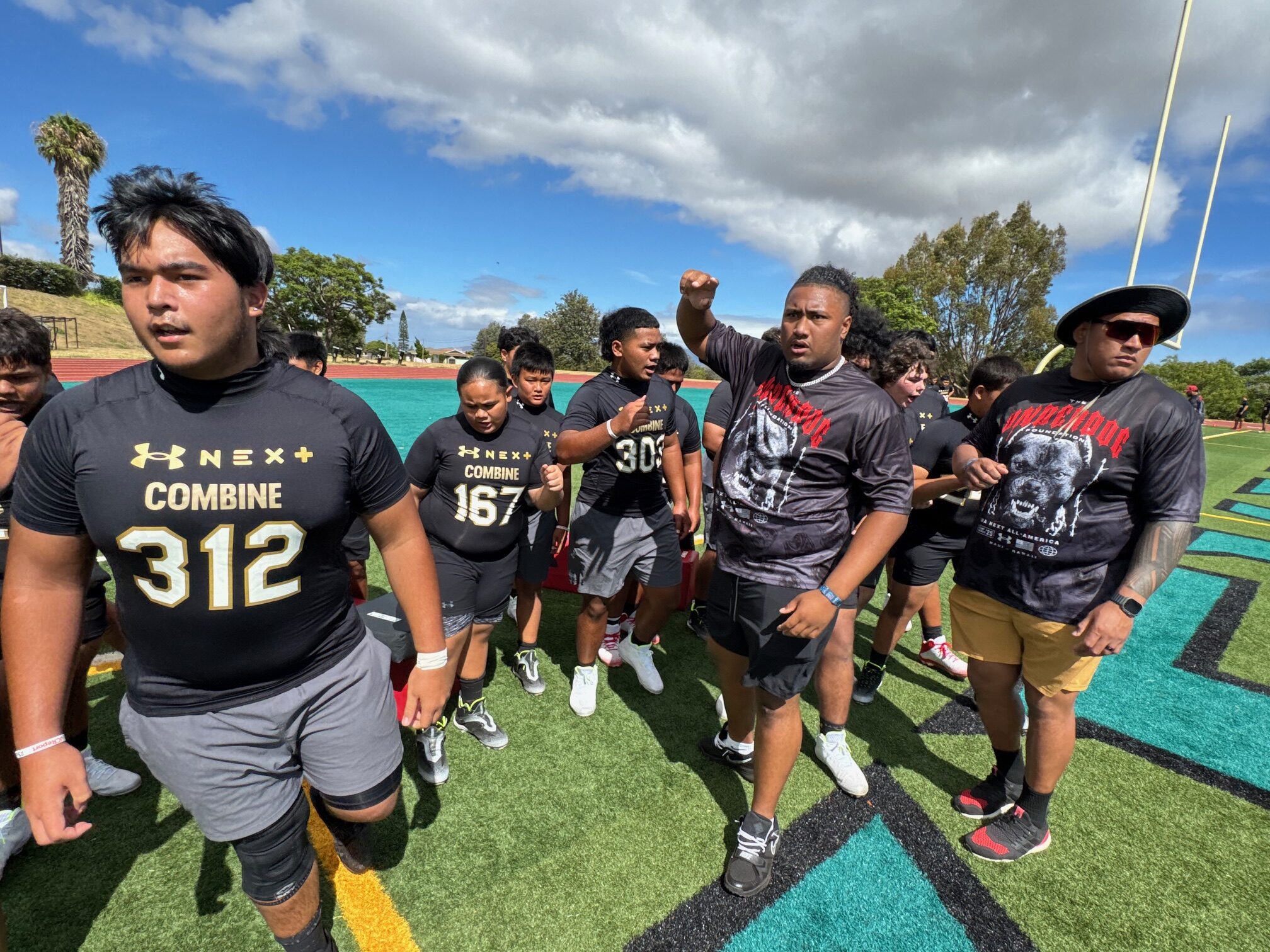 Iapani Laloulu (middle) points the direction for campers to go to their next drill at the Under Armour Next Camp on Saturday at King Kekaulike Stadium. HJI / ROB COLLIAS photo