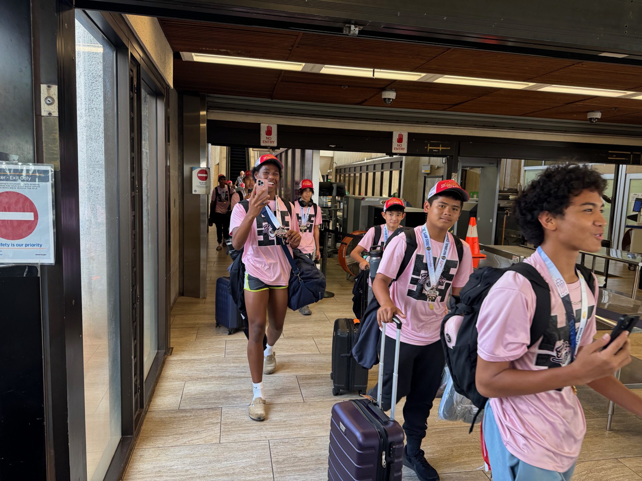 The Hawaiian Style Volleyball Club boys 15 USA Volleyball national champions come out of the secure area at Kahului Airport on Monday. HJI / ROB COLLIAS photo
