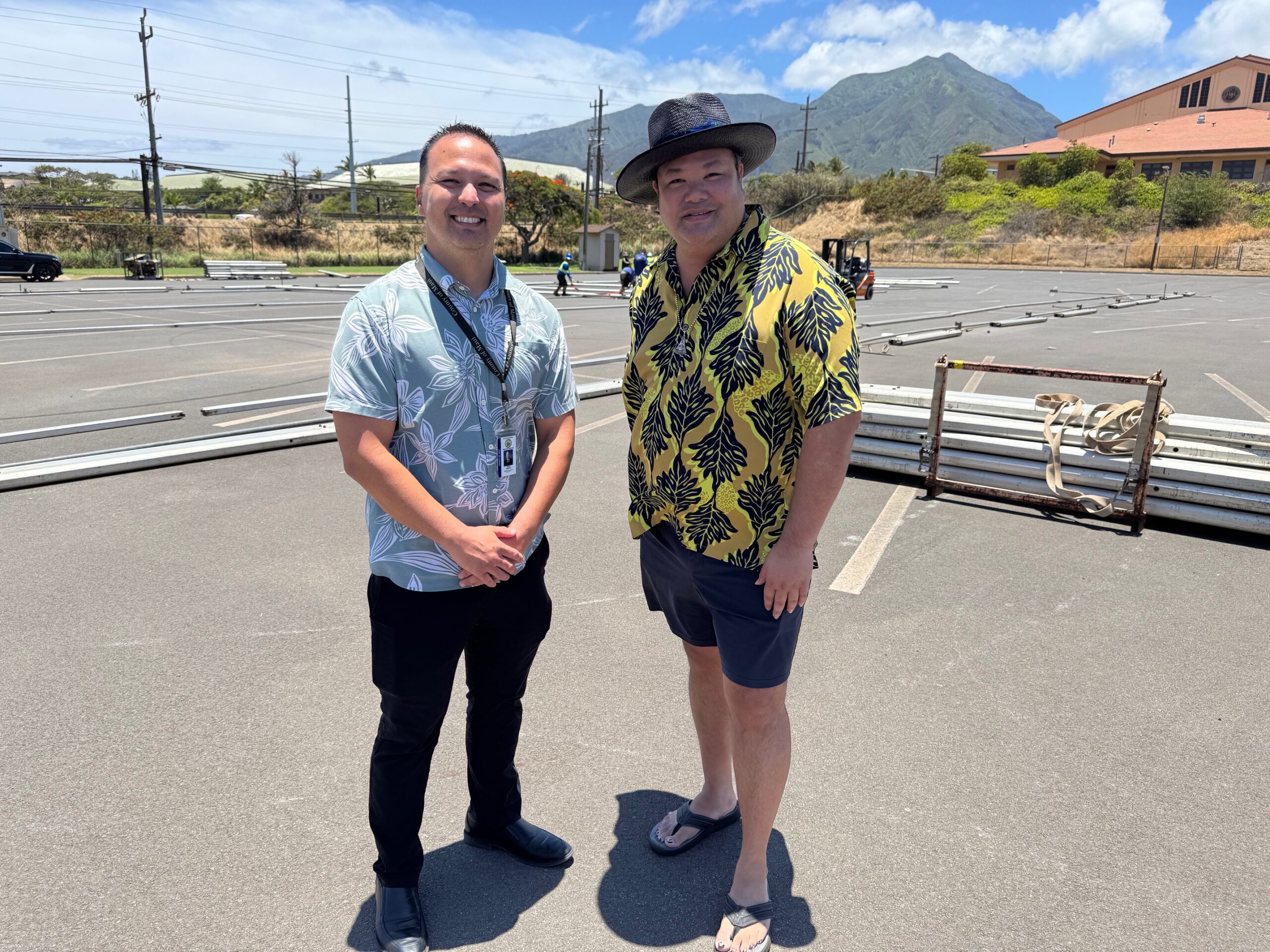Maui County managing director Josiah Nishita (left) and Daryl Fujiwara, the Maui County Fair coordinator, stand in the War Memorial Gym parking lot on Monday. HJI / ROB COLLIAS photo