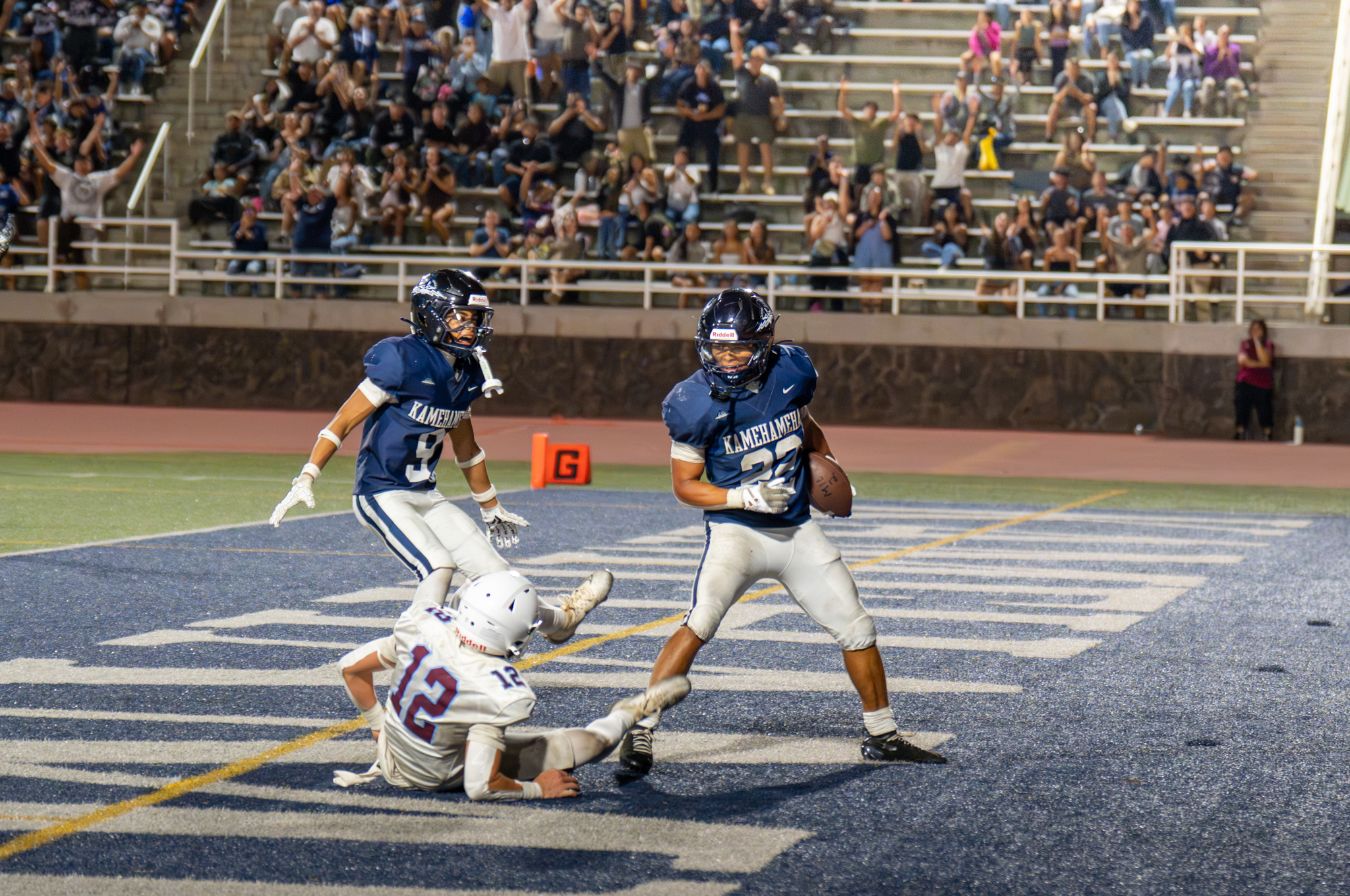 Kamehameha Schools Maui running back Zedekaiah Campbell (right, with ball) celebrates one of his three touchdowns in the Warriors' 28-21 win over Baldwin on Saturday at Kanaiaupuni Stadium. Looking on are Kamehameha Maui's Bruce Beltran and Baldwin's Jude Smith. KSBE / RYLEE SPARLING photo