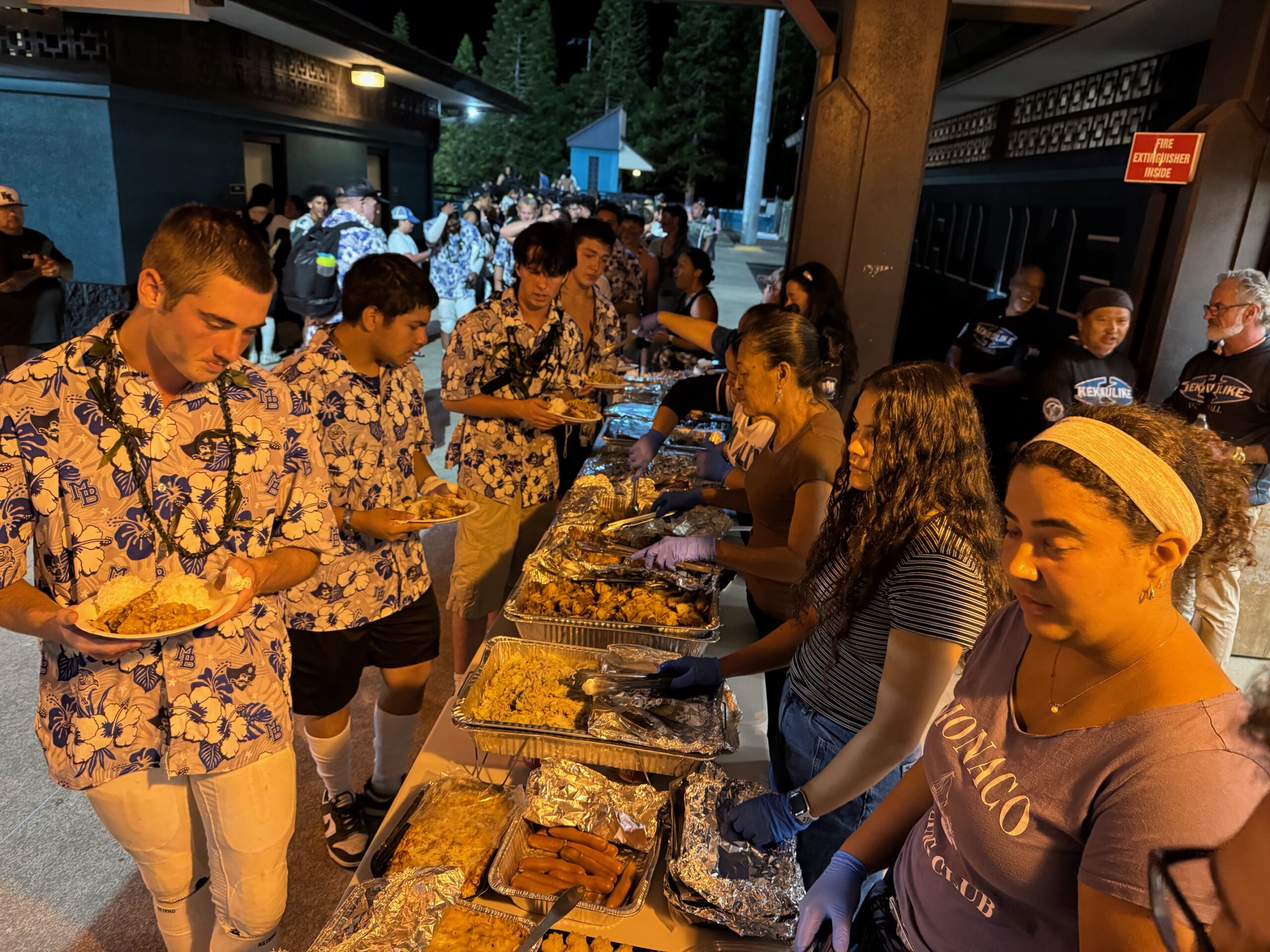 Morro Bay High School football players gop through the potluck line after their game against King Kekaulike on Saturday at King Kekaulike Stadium. HJI / ROB COLLIAS photo