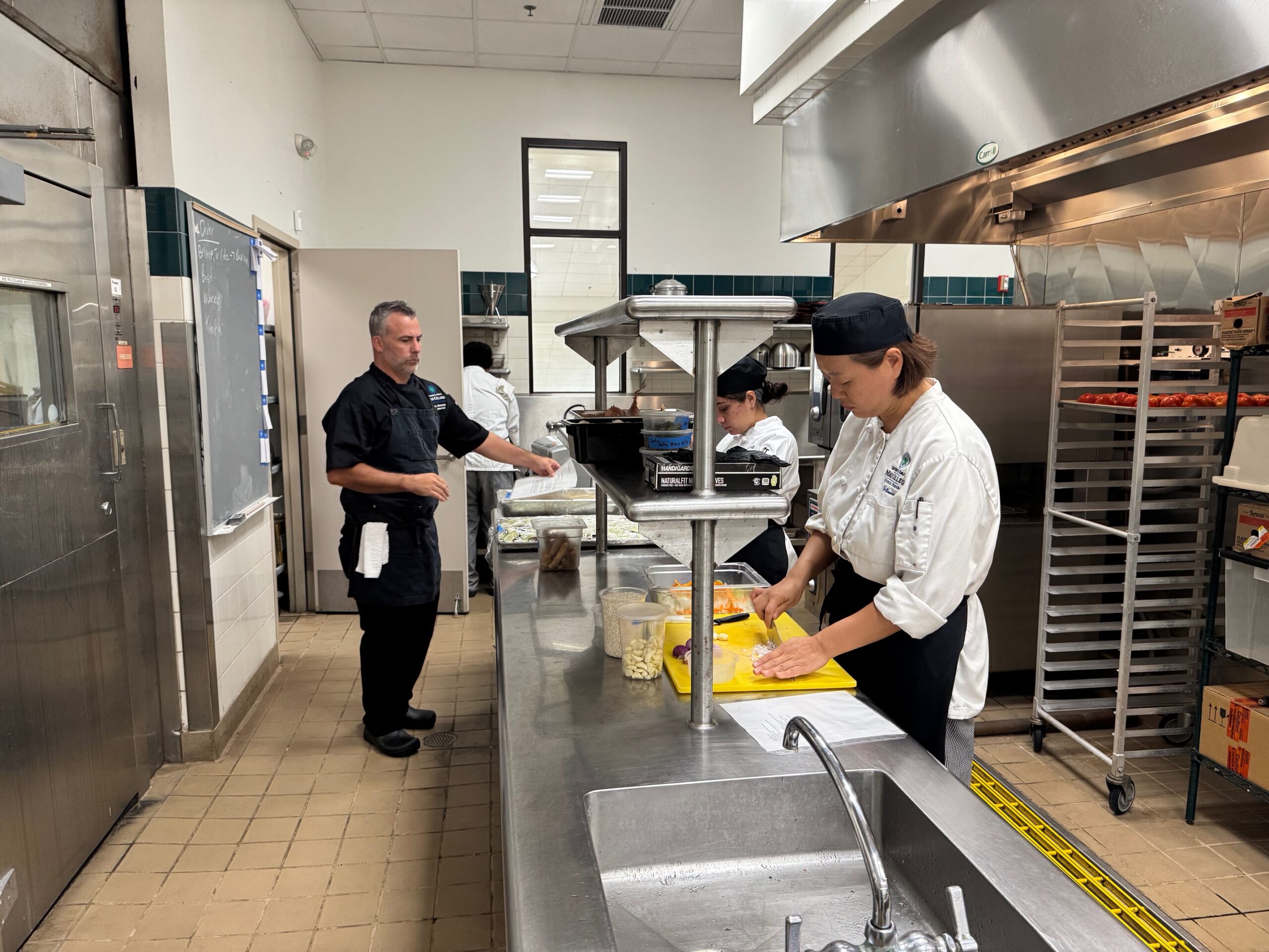 University of Hawai'i Maui College chef instructor Gary Johnson (in black) instructs students Friday, including You Joo Bonnes (right foreground). HJI / ROB COLLIASA photo