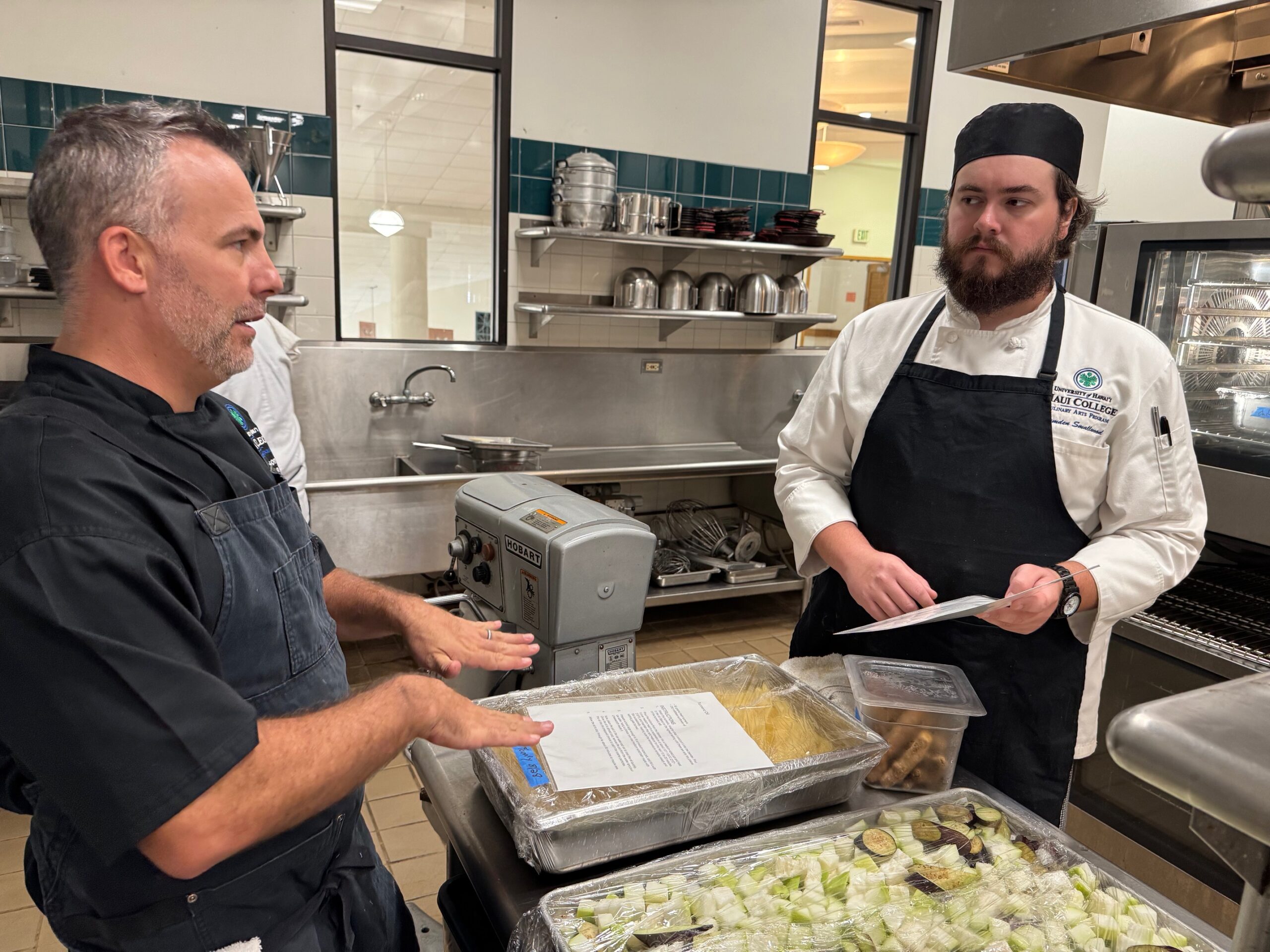 Chef instructor Gary Johnson left) dicusses things with culinary student Camden Smallwood on Friday in the Leis Family Class Act dining room kitchen at the University of Hawai'i Maui College. HJI / ROB COLLIAS photo