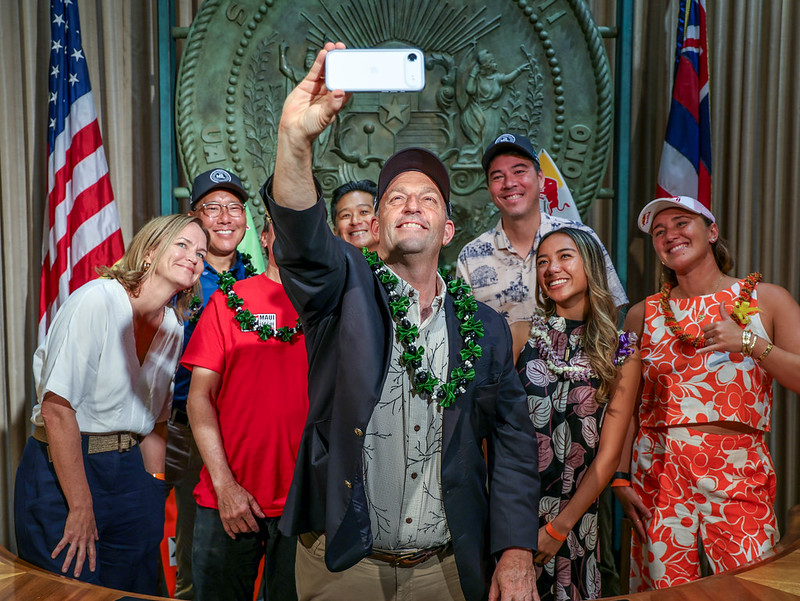 Hawai'i Gov. Josh Green takes a cellphone shot of the people involved in a news conference today to announce the official arrival of high school surfing statewide. The first state high school tournament will take place at Ho'okipa Beach Park on Maui May 1-2, 2026. Courtesy photo