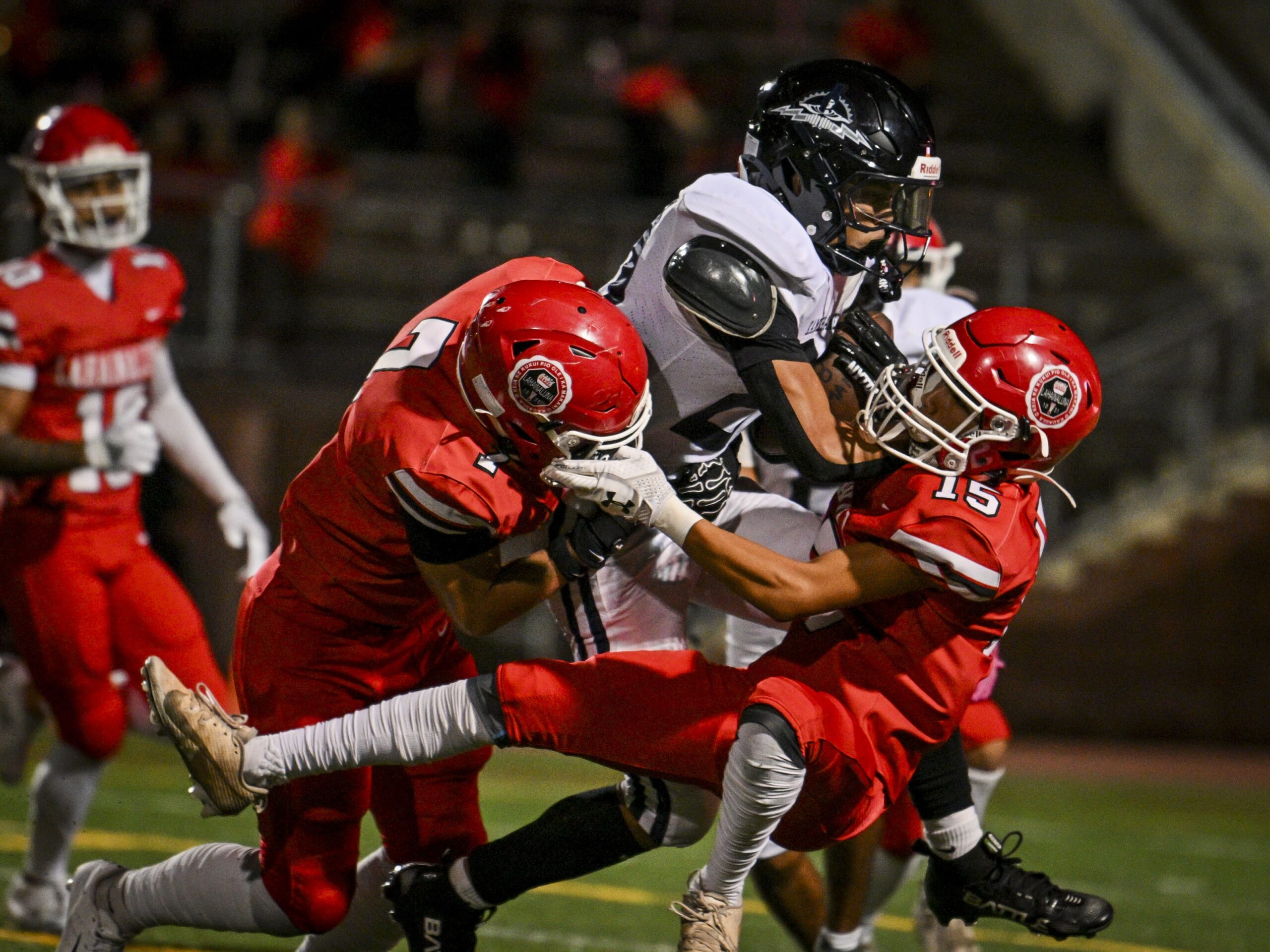 Lahainaluna High School's Taylor West (left) and Josiah Baybayan combine to tackle a Kamehameha Maui runner on Saturday in the Warriors' 36-0 win. GLEN PASCUAL photo