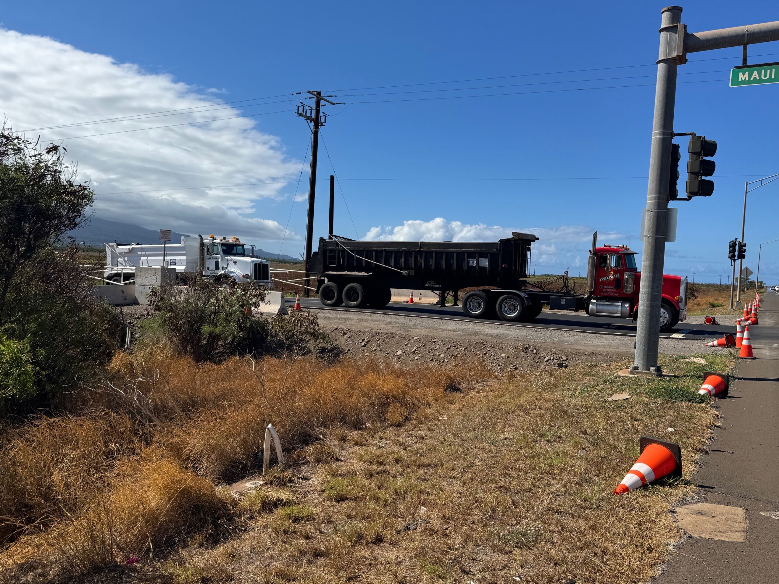 Local trucks wait to cross Maui Veterans Highway on their way to the Central Maui Landfill. This photo was taken Aug. 12. HJI / ROB COLLIAS photo