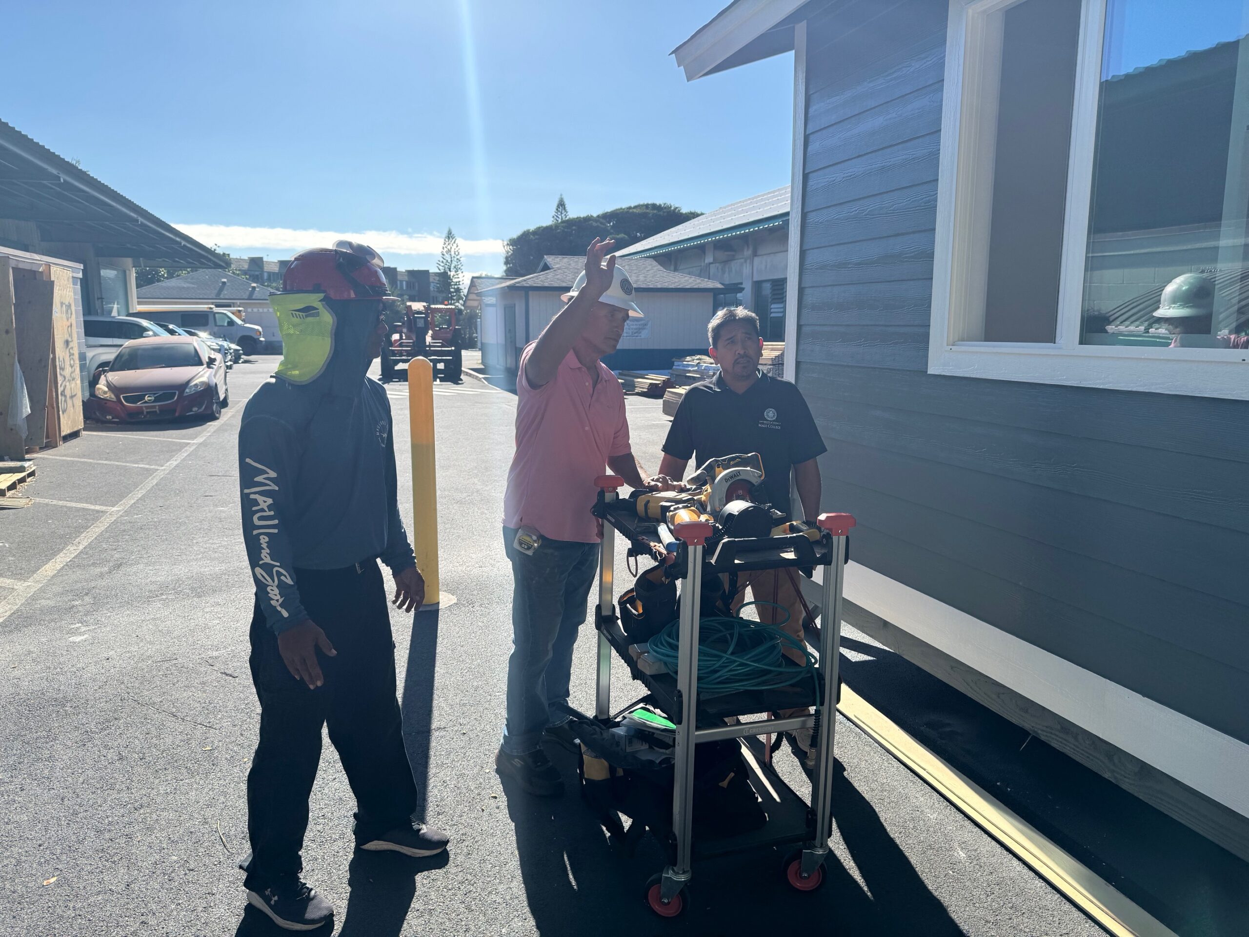 ConstructIon instructors (from left) Kainoa Mahoe, Ralph Canto and Roland Salcedo discuss the sheds they are gui9ding students at the University of Hawai'i Maui College build for Lahaina fire survivors on Wednesday. HJI / ROB COLLIAS photo