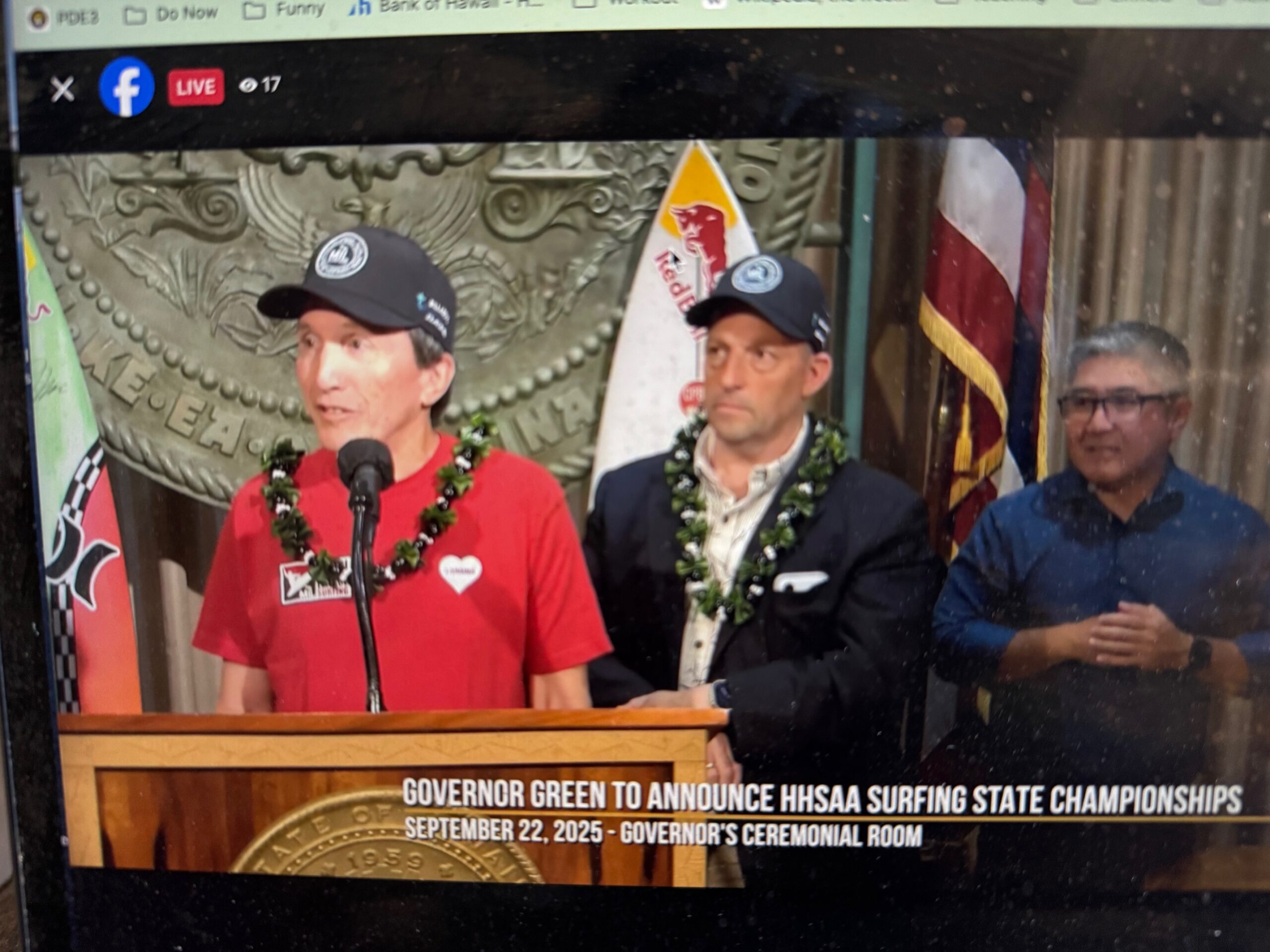 Kim Ball, the founder of Maui Interscholastic League surfing, answers questions at a news conference at the state capitol today while standing in front of Gov. Josh Green. Screenshot photo