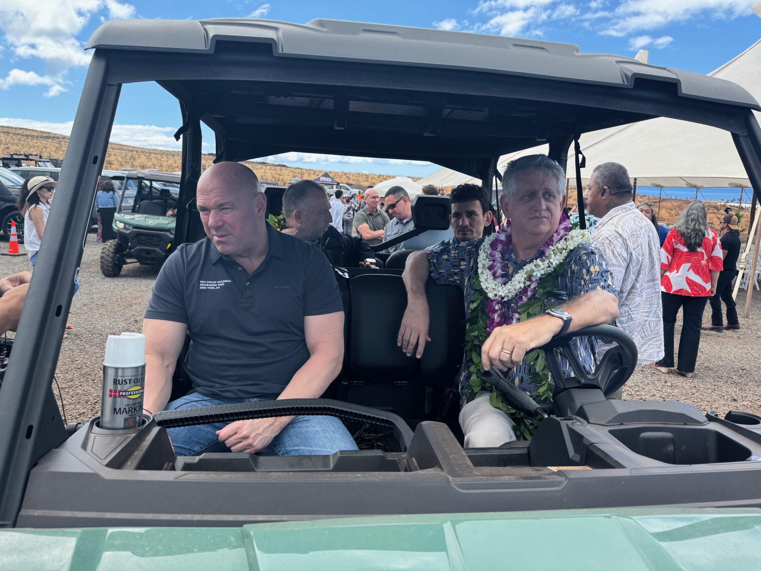 UFC president and CEO Dana White (left front) sits in a golf cart with Department of Human Services Deputy Director Joseph Campos (right front) while Hawai'i Gov. Josh Green speaks with UFC BMF champion Max Holloway in the backseat. HJI / ROB COLLIAS photo