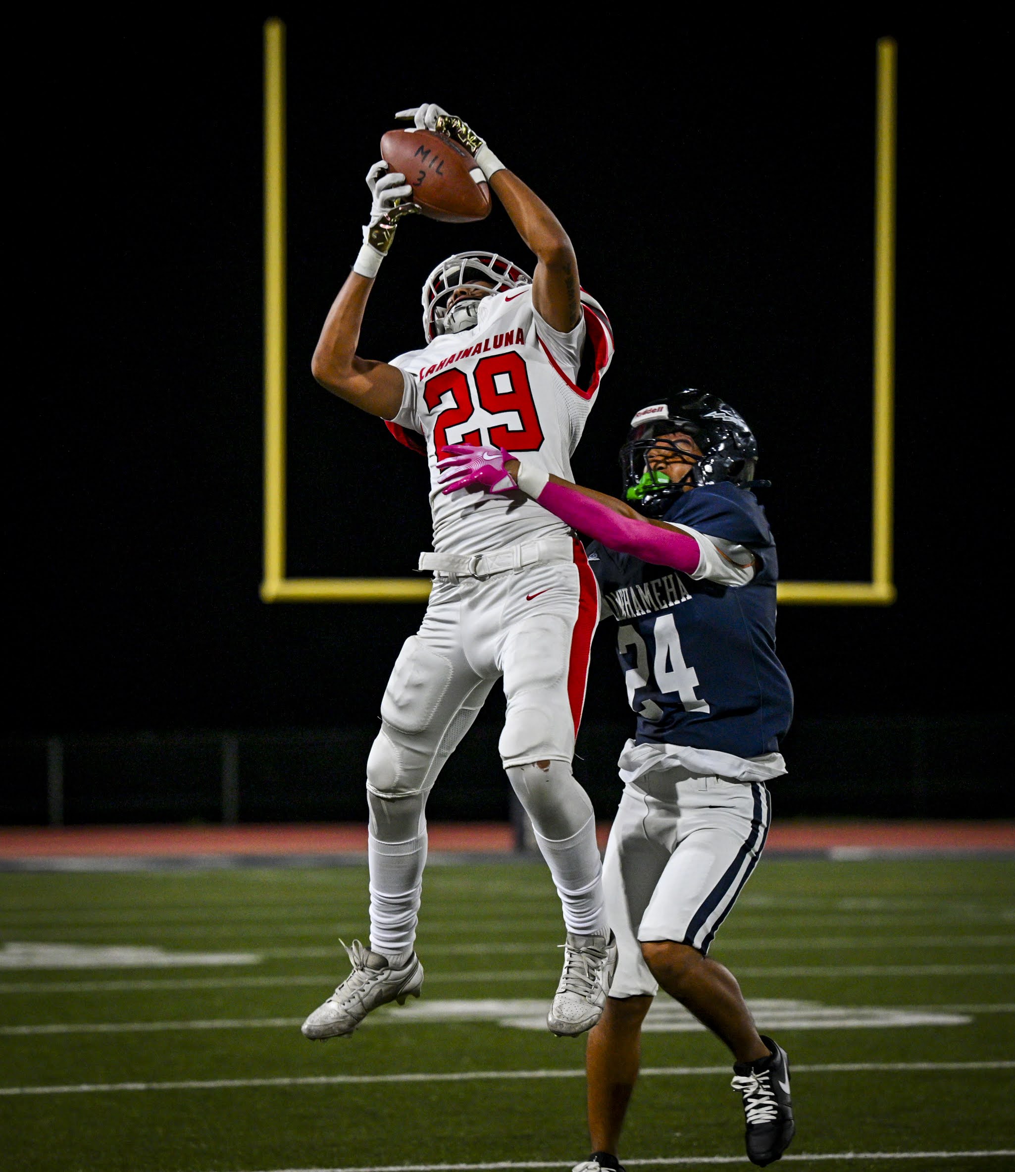 Lahainaluna High School's Masa Cabrera makes a catch in front of Kamehameha Maui's Tali Buenconsejo on Friday in the Warriors' 27-7 win over the Lunas. GLEN PASCUAL photo