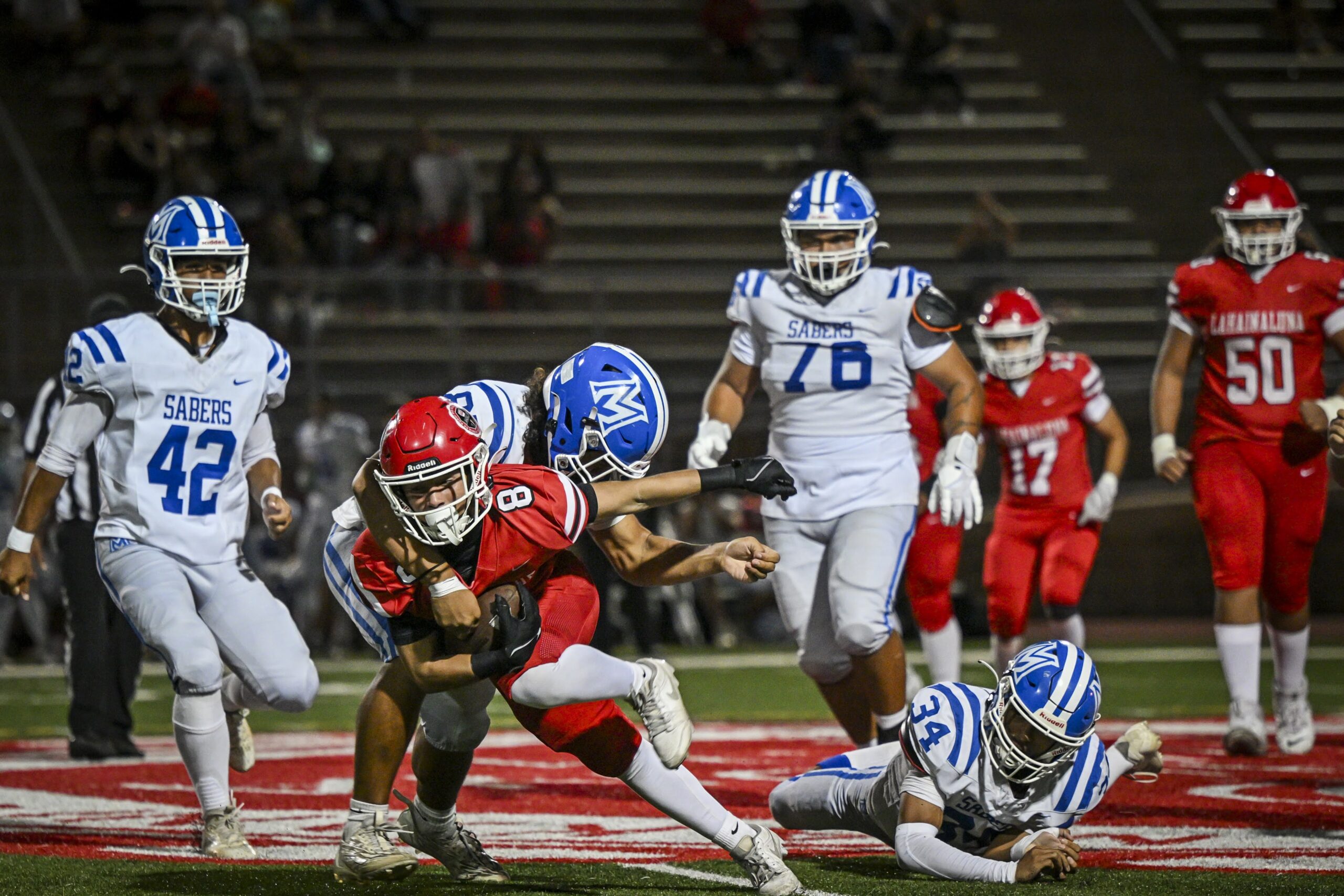 Lahainaluna High School's Kua Bacalso is tackled by a Maui High defender on Friday night at Sue Cooley Stadium. The Lunas won the game 34-9 to stay alive in the MIL Division I second-round race. GLEN PASCUAL photo