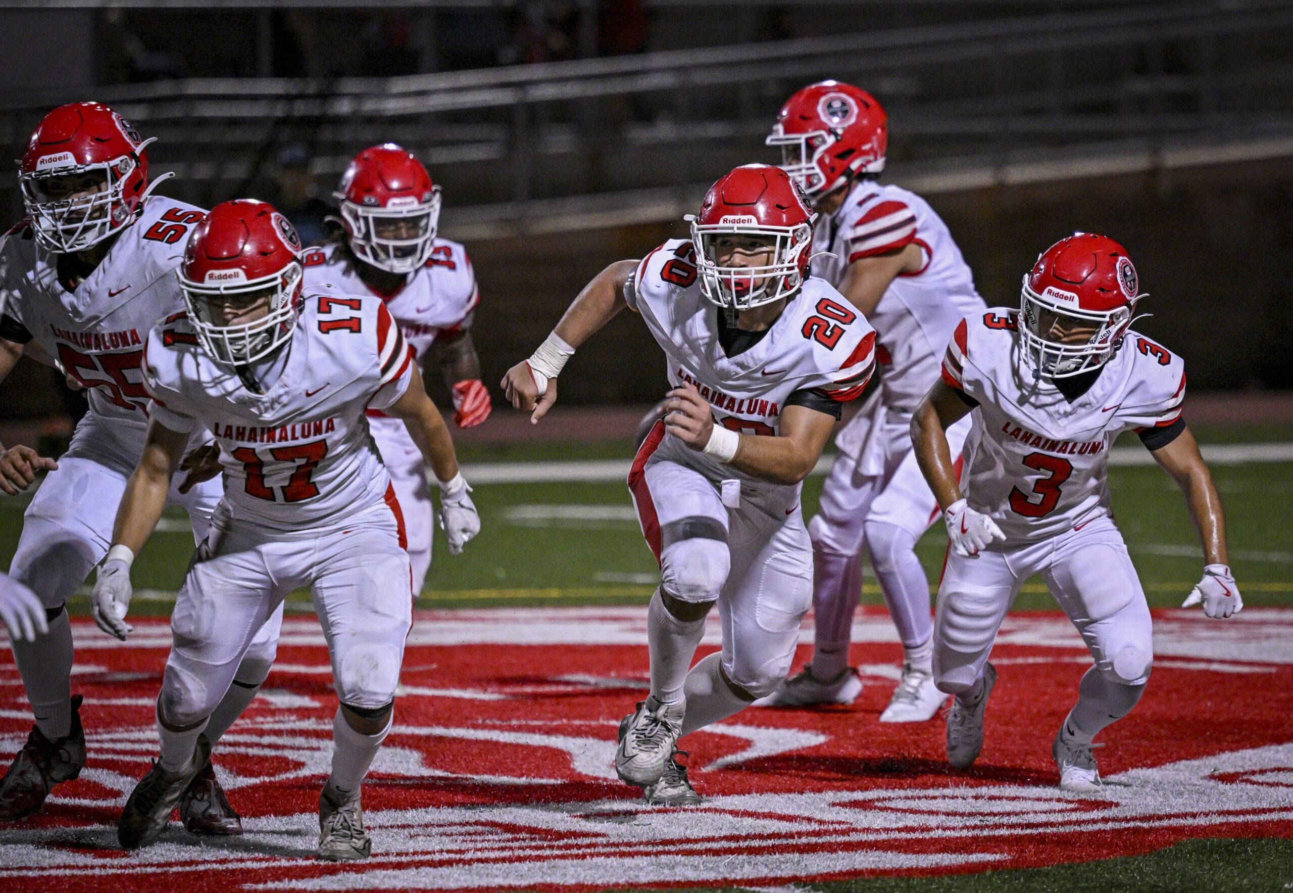 Lahainaluna's Eder Valdez (17), Chase Loebl (20) and Joseph Arcangel (3) lead the blocking line for Kyle Thomas (third from left) in the Lunas' 14-7 loss to Baldwin on Saturday. GLEN PASCUAL photo
