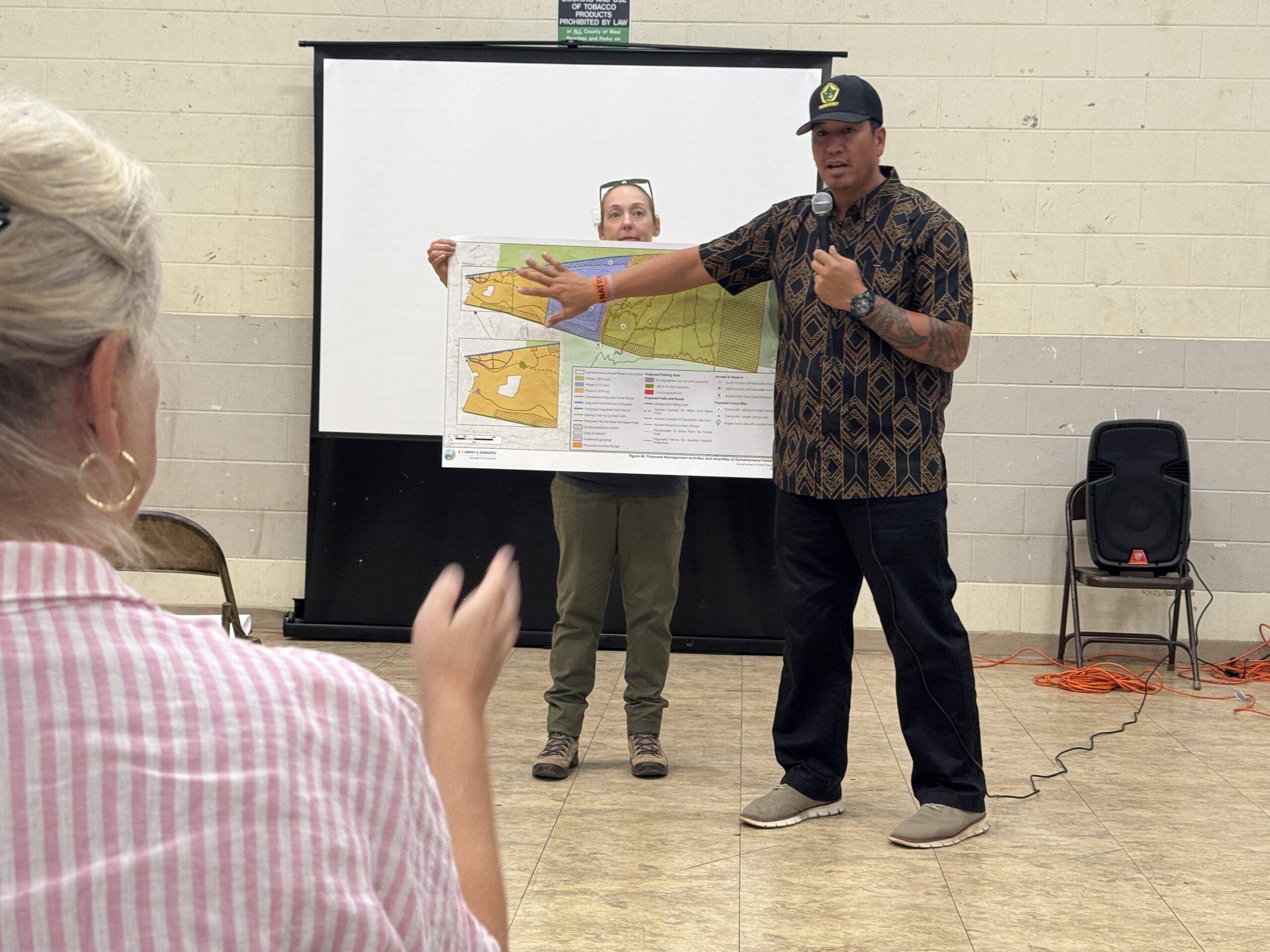Lance De Silva points out some features of the Kamehamenui parcel to the public meeting Wednesday at Kula Community Center as Stephanie Franklin holds the map. HJI / ROB COLLIAS photo