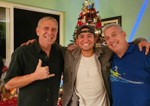 From left, Paul Tonnessen, Nick Mendez and Richard Carr stand in front of their Christmas tree in 2024. Courtsey photo
