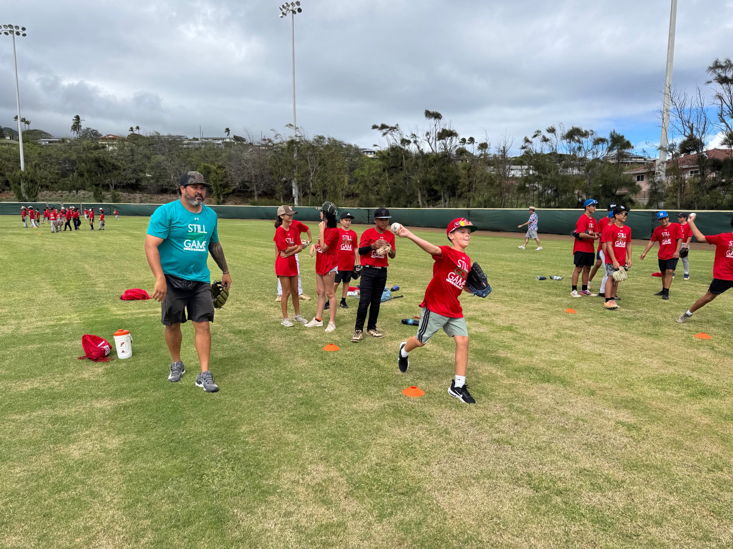 Kanekoa Texeira (left) works with young baseball players on Sunday at Maehara Stadium. HJI / ROB COLLIAS photo