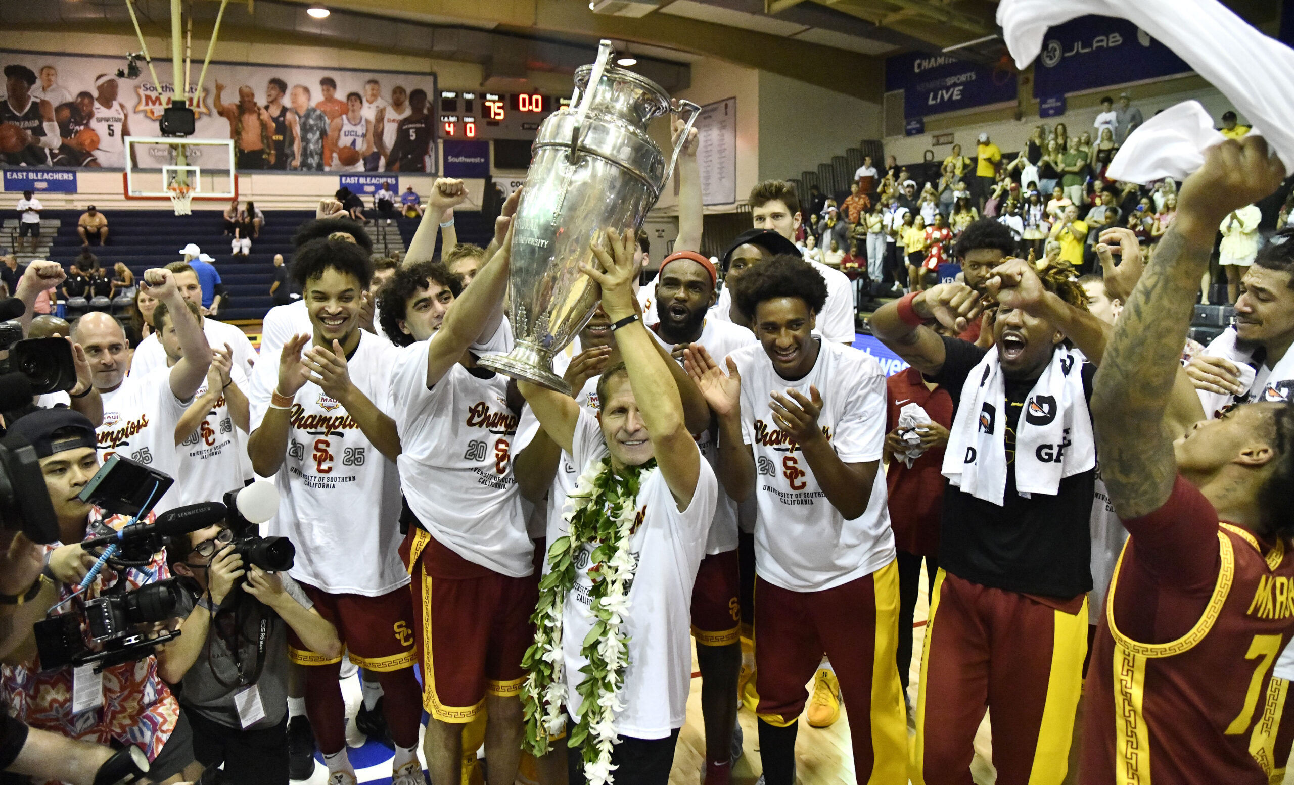 Southern California head coach Eric Musselman lofts the Wayne Duke Trophy after his team's 88-75 win over Arizona State in the Southwest Maui Invitational championship game at Lahaina Civic Center. MATTHEW THAYER photo