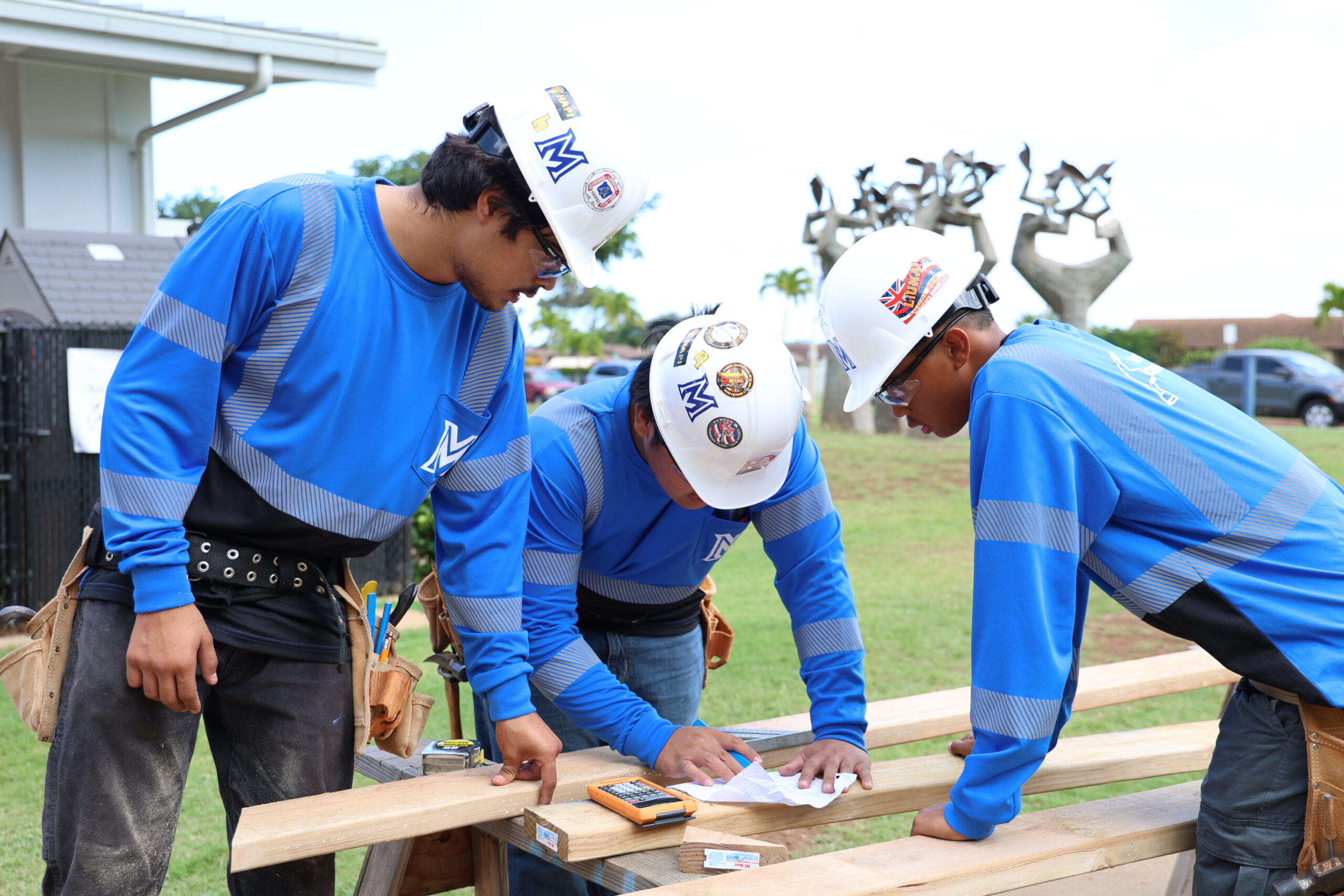 From left, Maui High School construction students Kalani Sanchez-Lizarraga, a senior; Howard Cacayorin, a senior; and Denver Sabas, a junior, work during the construction showcase held at the Kahului school on Dec. 12. ALEIZAY ANGEL photo