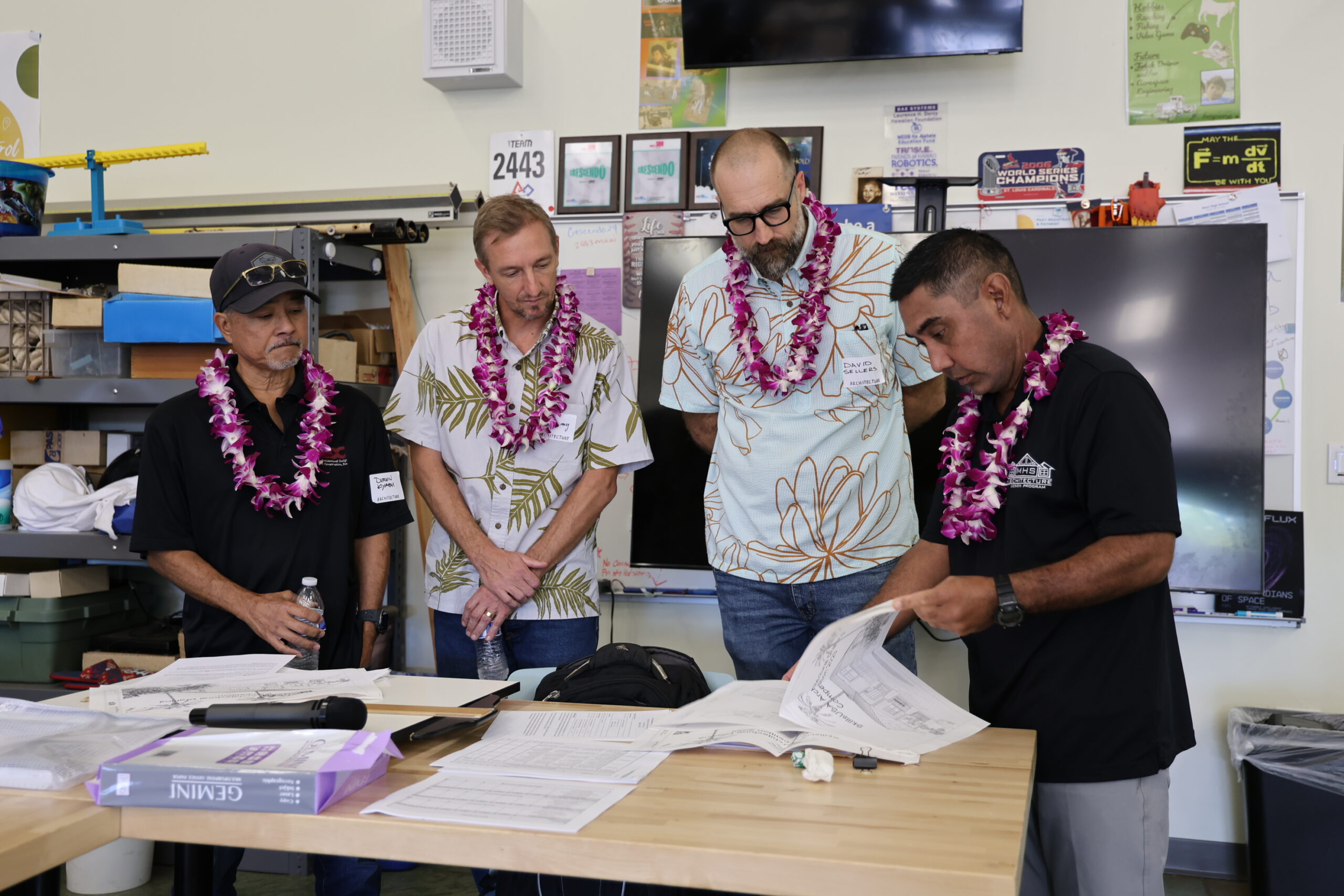 From left, Maui High School architecture design judges Durwin Kiyabu of Durwin Kiyabu of Architectural Design & Construction, Inc.; Jeremy Stoddart, AIA- Maui Chapter President of Pili Design Build; David Sellers of Hawaii Off Grid Architecture & Engineering; and Maui High architecture teacher Mike Sado look over students' work on Friday. Courtesy photo