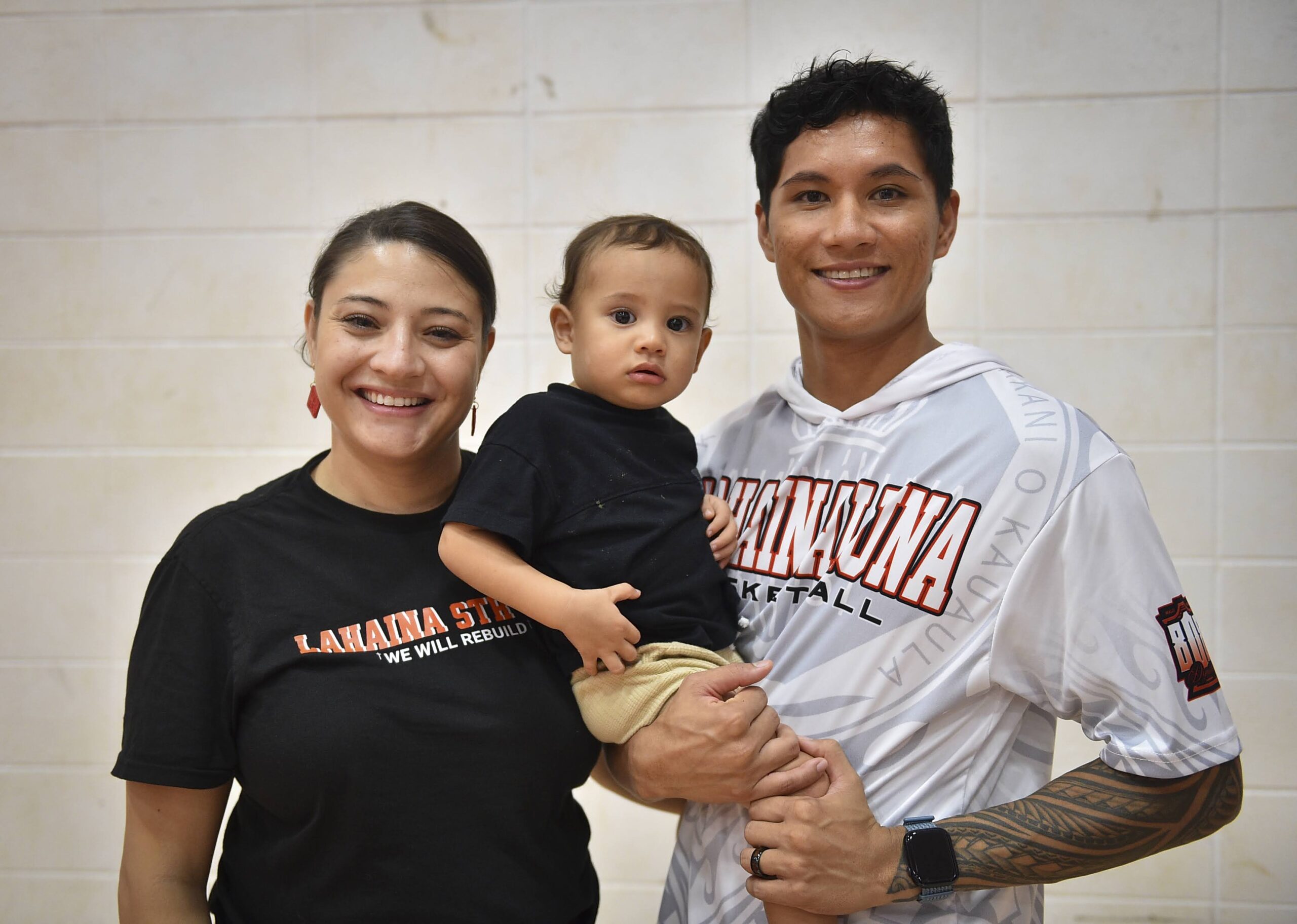 Makayla and T.J. Rickard and 1-year-old son Rush pose for this photo at Lahainaluna High School gym on Tuesday. The Rickards moved out of FEMA leased housing in June and now rent a home in Wailuku for $3,700. GLEN PASCUAL photo