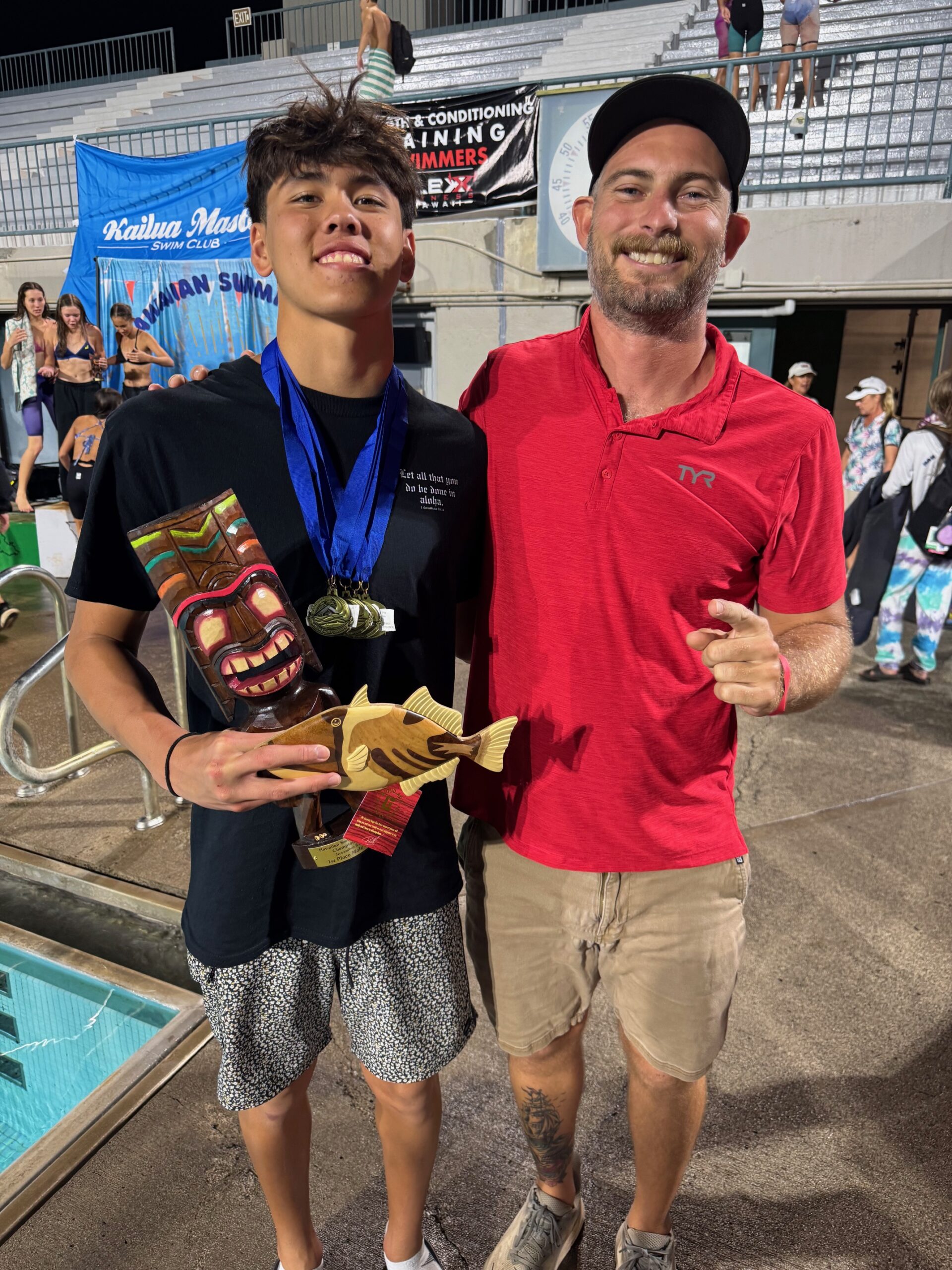 Cruz Storer (left) shows off his hardware from the state age group meet held on O'ahu from Nov. 21-23 as he st6andss next to Lahaina Swim Club coach Jack Pope. REID YAMAMOTO photo