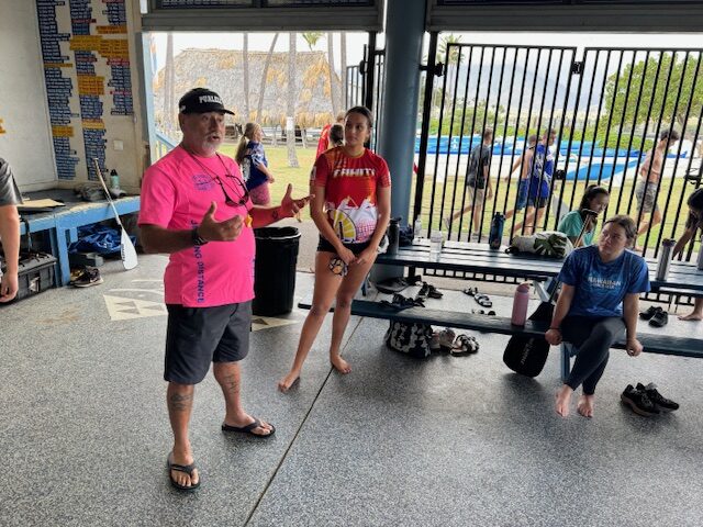 Hawaiian Canoe Club keiki coach Paul Lu'uwai talks to his paddlers on Wednesday while Keala Rodrizuez (red shirt) looks on. HJI / ROB COLLIAS photo