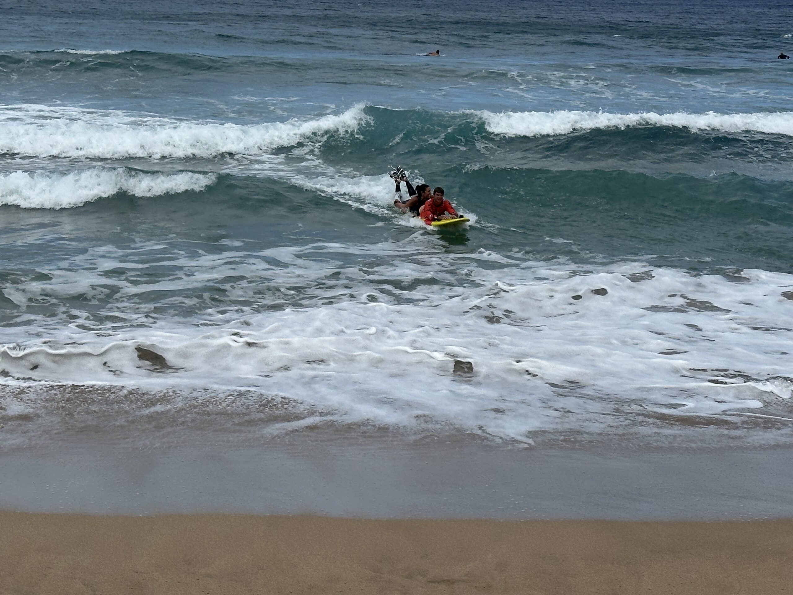 Leslie Hainsworth brings in a victim (Zane Schweitzer) to the beach on a rescue board. Hainsworth coaches Maui Prep while Schweitzer coaches Lahainaluna. KIM BALL photo