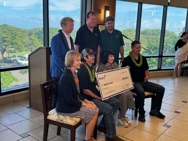 Sentry Insurance officials Pete McPartland (back row, far left) and Stephanie Smith (holding check, front row) were part of a news conference on Tuesday to announce $1 million in donations to three Maui charities. HJI / ROB COLLIAS photo
