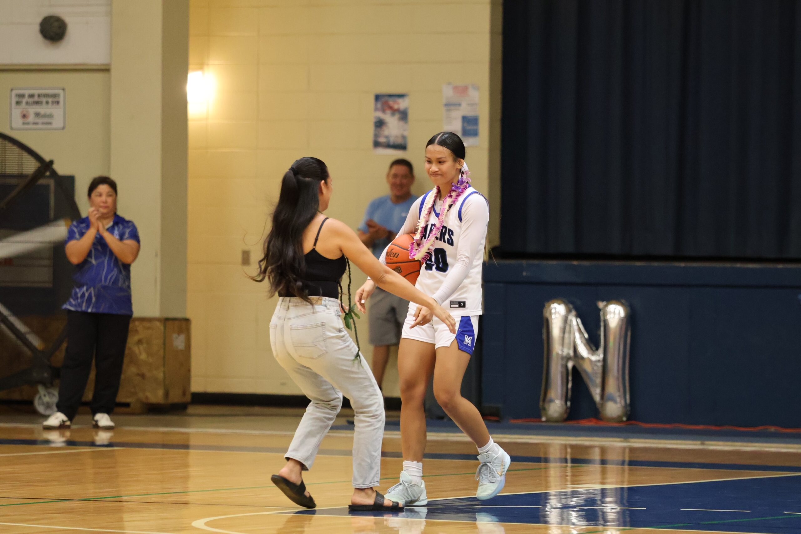 Crystal Bal greets her oldest daughter Naiara Bal on Naiara's senior night on Tuesday at the Maui High School gym. REID YAMAMOTO photo