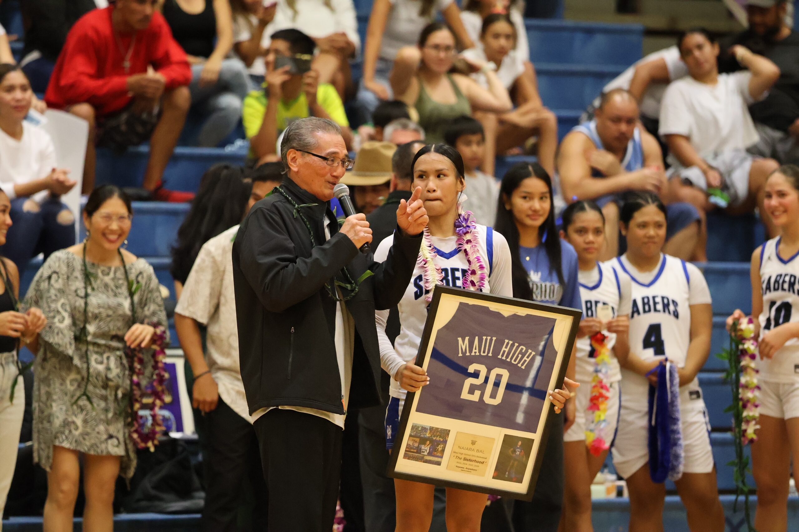 Gilbert Silva speaks to the crowd at the Izumi "Shine" Matsui Athletic Center on the Maui High School campus as his granddaughter Naiara Bal holds her jersey on her senior night Tuesday, Jan. 20, 2026. REID YAMAMOTO photo