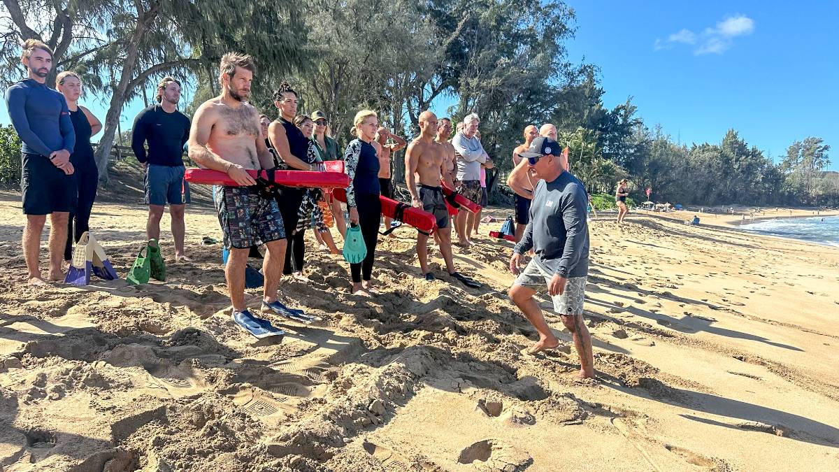 Archie Kalepa (black shirt, right) instructs high school surfing coaches on proper use of rescue tubes on Sunday at D.T. Fleming Beach Park. KIM BALL photo