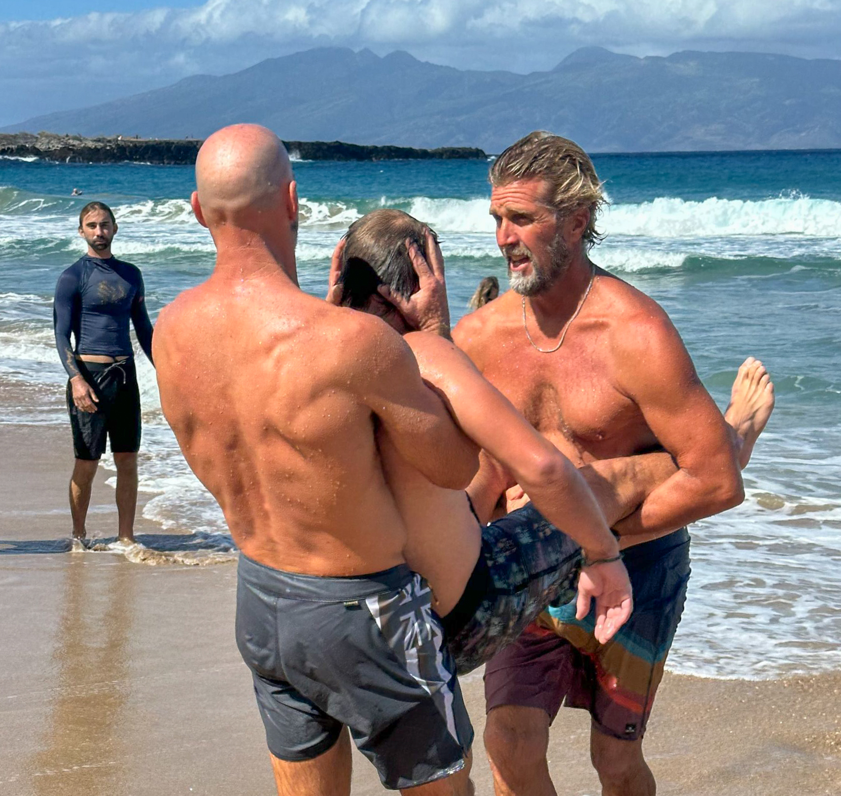 Steve Thobe (right), a Seabury Hall coach and Collin Shield (left), a Kealakehe coach, use proper technique in carrying a victim (Haleakala Waldorf coach Jason Ward) with a spinal injury. KIM BALL photo
