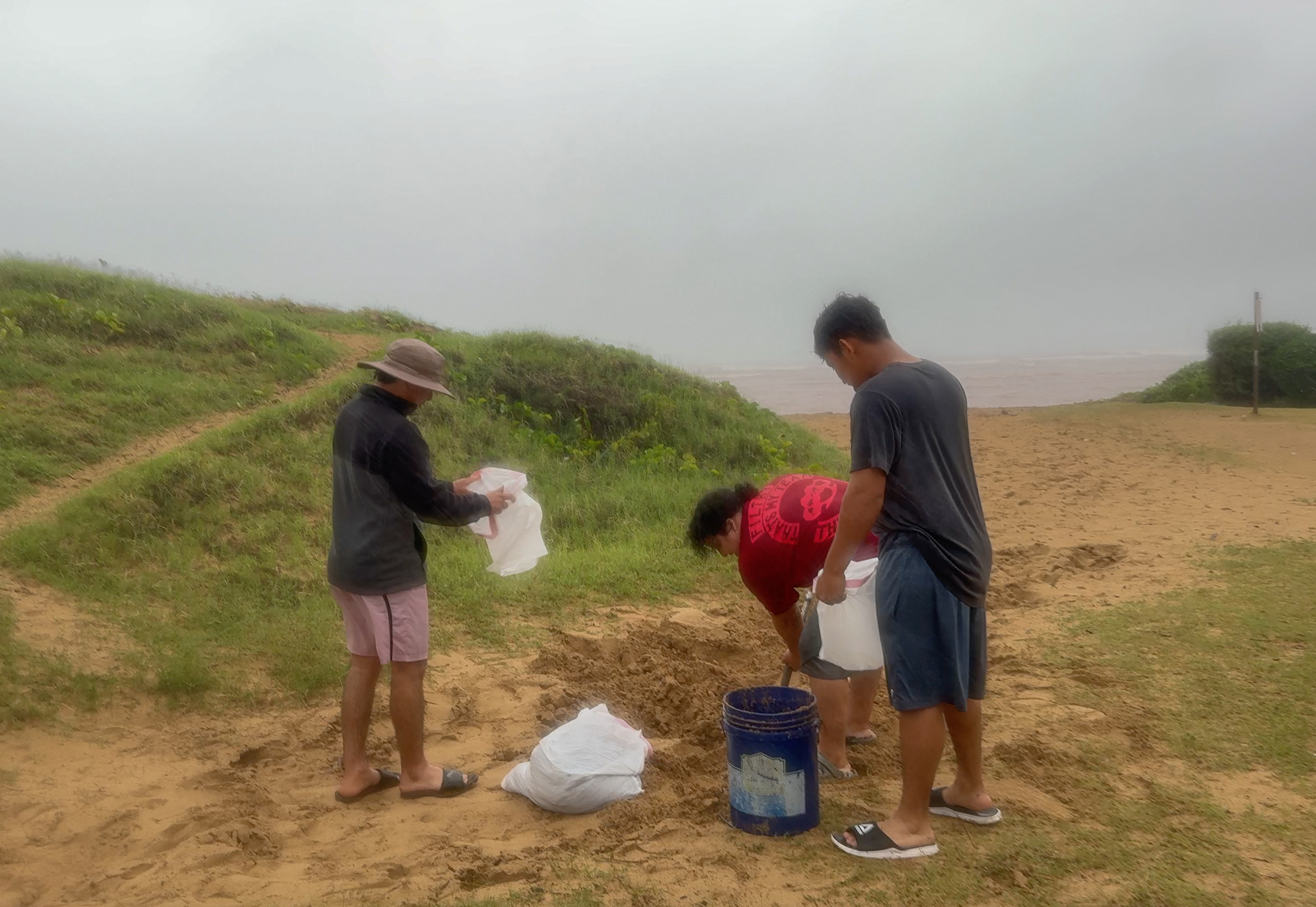 A group of young men made makeshift sandbags with water already a foot high in their home in Kīhei on March 14, 2026. HJI / Cammy Clark photo