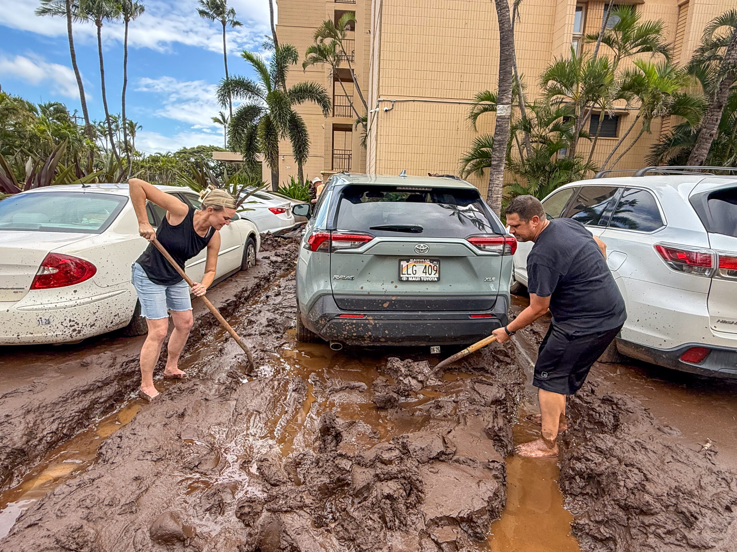 Staci and Sean Ortega from Arizona try to shovel out the mud from their rental car from the parking lot of Koa Lagoon in Kīhei in hopes of being able to make a getaway later Sunday to the west side of Maui. HJI / Cammy Clark photo